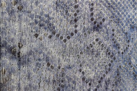 Texture of reptile pattern on genuine leather close-up, surface of grey color, trendy background. Fashion shopping, manufacturing