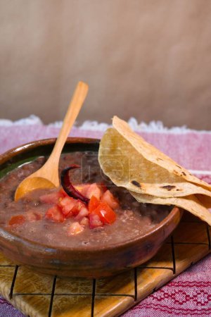 Foto de A Frijoles cocidos en un plato de barro con tomate y tortillas, plato pobre mexicano - Imagen libre de derechos