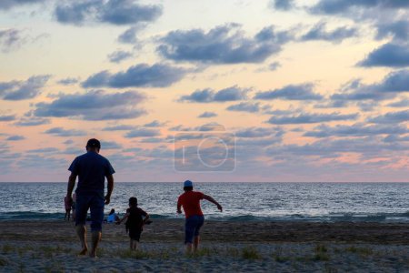 Foto de A Family playing on the beach at beautiful sunset with sunset - Imagen libre de derechos