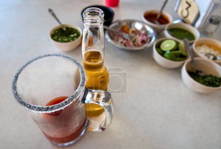Ein mexikanisches Michelada-Getränk aus Bier, Tomatensaft, Zitrone und Salz. Mit Platz für Text.