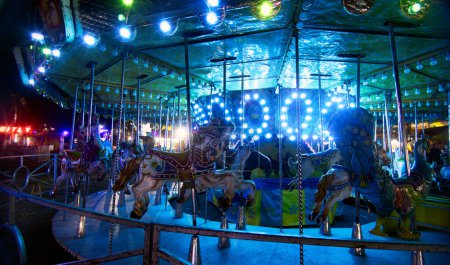 A horse carousel with lights at night, with space for text