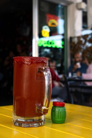 Una Michelada, bebida mexicana de cerveza, clamato, salda, limón y chamoy, con espacio para texto
