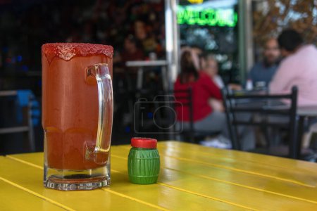 Una Michelada, bebida mexicana de cerveza, clamato, salda, limón y chamoy, con espacio para texto