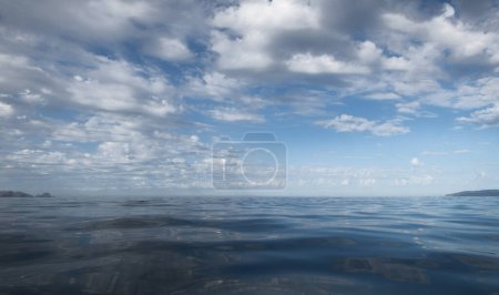 Téléchargez les photos : Un fond de nuages blancs et leur réflexion en pleine mer, avec espace pour le texte - en image libre de droit