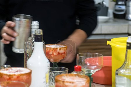 A Making strawberry margaritas with ice, chili and lemon
