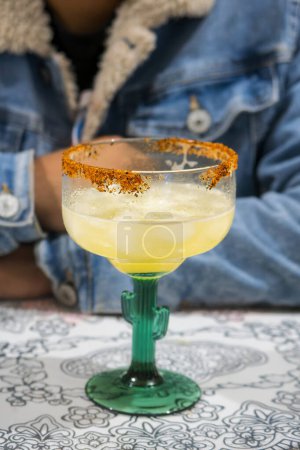 A Preparing pineapple margaritas with ice, chili and lemon