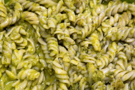 A Fusilli pasta with pesto sauce, with space for text