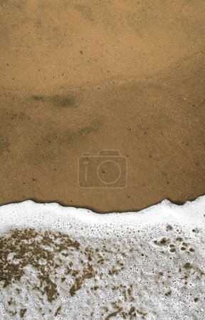 A Background of sea foam on the beach on the sand, with space for text
