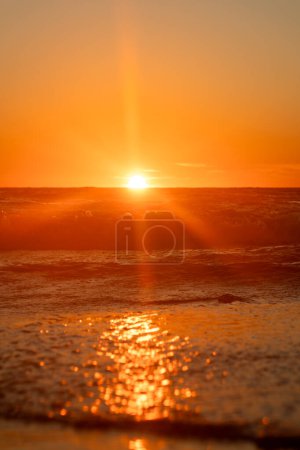 Ein Sonnenuntergang mit Sonnenstrahlen am Strand, mystische Szene mit Platz für Text
