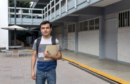 Male student at the university holding a paper in his hand