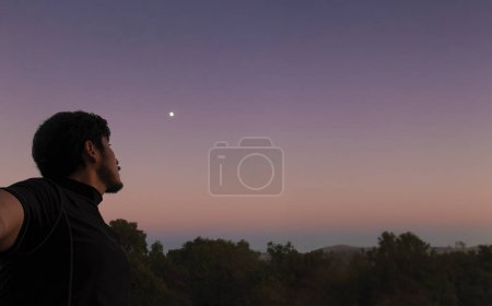 A Thoughtful man looking at the sky with beautiful sunset in the background and space for text