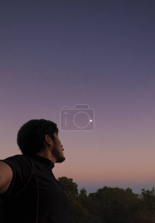 Un homme réfléchi regardant le ciel avec un beau coucher de soleil en arrière-plan et de l'espace pour le texte