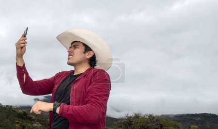 Un hombre del rancho con su teléfono buscando señal en el área rural