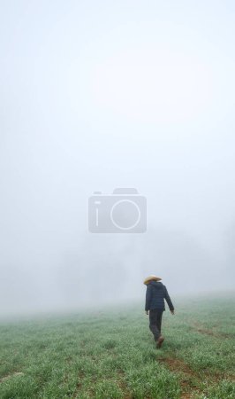 Foto de Un hombre vaquero caminando entre un bosque brumoso con espacio para el texto - Imagen libre de derechos