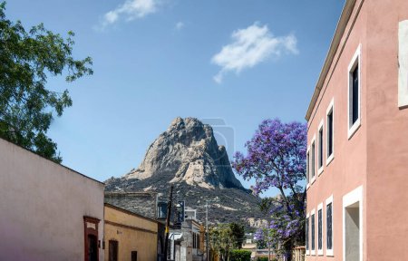 A Mexican town with old houses and jacaranda flowers, Bernal Peak, Monolith in Queretaro, Mexico.