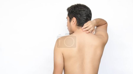 Ein Mann ohne Hemd wandte sich ab, zeigte seinen Rücken und Kopf, berührte seinen oberen Rücken vor Schmerzen mit der Hand, weißer Hintergrund, links Platz für Text