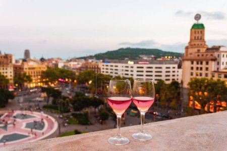 Photo for Two glasses of red wine on the background of the central square of Barcelona at sunset. Panoramic view of the Spanish city. High quality photo - Royalty Free Image