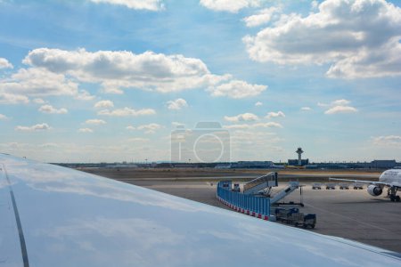 Téléchargez les photos : Aéroport de Francfort Allemagne 02 août 2022 - Vue par la fenêtre sur une aile d'avion avec vue sur l'aéroport avec ciel bleu - en image libre de droit