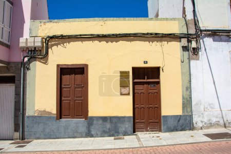 Téléchargez les photos : Vieille fenêtre avec lignes électriques et une porte d'entrée sur une maison sur l'île Canaries de Gran Canaria en Espagne - en image libre de droit
