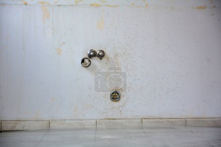 Wand mit Wasser- und Stromanschlüssen in einer Küche während der Renovierung während eines Umzugs