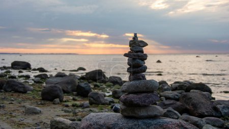Stacked stones on a beach on the Baltic Sea coast at sunset