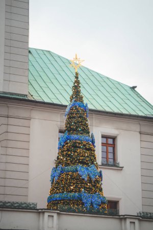 Photo for 3.12. 2022 - Gliwice, Poland. Christmas tree with blue chain and yellow lights on the roof of the church in the main square. - Royalty Free Image