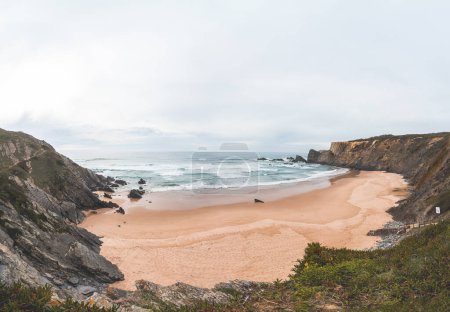 Photo for Panorama of the beautiful Praia da Amalia beach at sunset on the Fisherman Trail, which lines the Atlantic coast in the west of Portugal. A well-known tourist destination. - Royalty Free Image