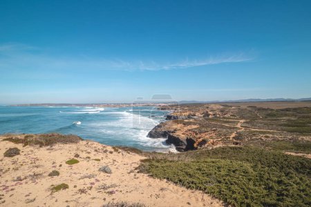 Foto de Paisaje rocoso montañoso e inestable en la costa atlántica en un día soleado en la región de Odemira, al oeste de Portugal. Paseando por el Sendero del Pescador, Rota Vicentina. - Imagen libre de derechos
