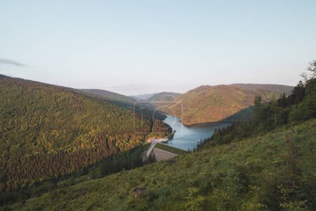 Photo for Sunset over the Sance dam near Ostravice in the middle of Beskydy mountains. View of the dam set in a hilly and forested environment. Drinking water reservoir. - Royalty Free Image