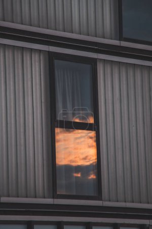 Photo for Reflection of a breathtaking dramatic sunset in the window of a skyscraper in Almere, Netherlands. Dutch sunset. - Royalty Free Image