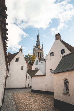 Historisches Zentrum von Begijnhof in Kortrijk mit dem Belfried von Courtrai im Hintergrund. Eine Sammlung individueller und / oder gemeinschaftlicher Häuser, Häuser und Klöster der Beginen.