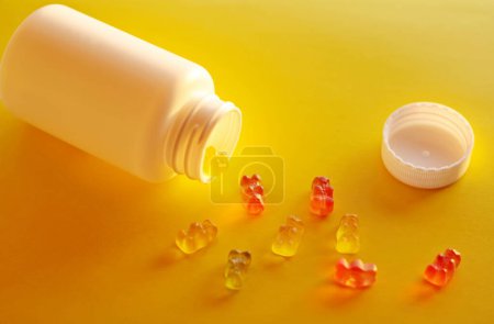 Téléchargez les photos : Vitamines pour enfants gelée ours sur un fond jaune - en image libre de droit