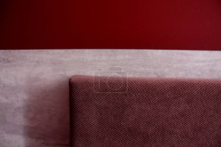 Foto de Fragmento de la suave parte posterior de la cama cerca de la pared roja - Imagen libre de derechos