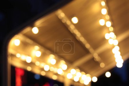 cafe canopy with lights garlands on the street, bokeh