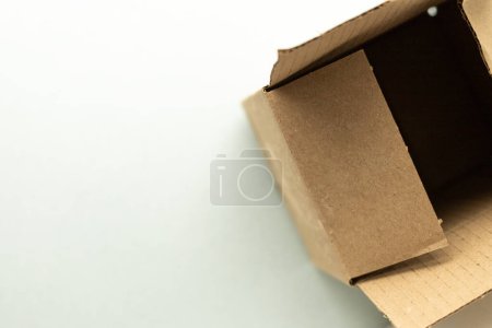 open cardboard box on soft blue background, top view