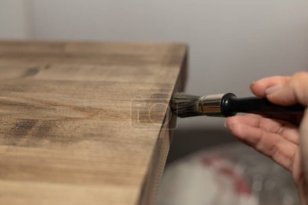 revêtement avec une huile de couleur pinceau d'un bouclier de frêne en bois