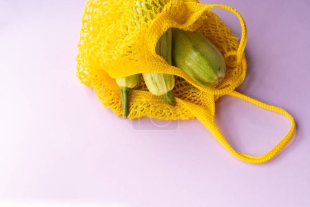 Photo for Three green zucchini in a yellow bowl, eco ba - Royalty Free Image