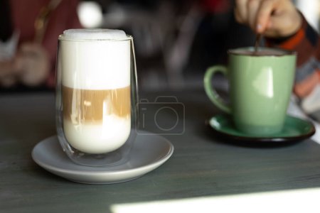 Photo for Coffee latte in a transparent glass with white foam - Royalty Free Image