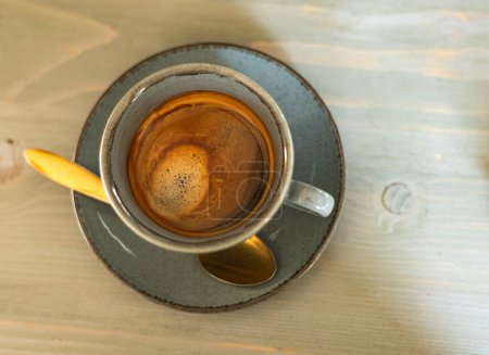 Foto de Café negro en una taza con una cuchara de oro, vista superior - Imagen libre de derechos