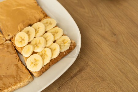 toast with banana and peanut butter on a white plate