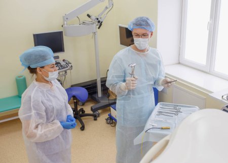 Foto de Un proctólogo prepara instrumentos de expansión para la cirugía en el quirófano proctológico - Imagen libre de derechos