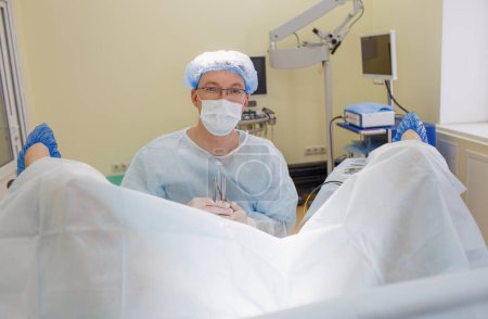 Foto de El proctólogo mira a la cámara durante el examen del paciente. Primer plano - Imagen libre de derechos