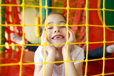 Téléchargez les photos : Une petite fille frémit dans un centre de jeux pour enfants. - en image libre de droit