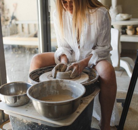 Photo for A woman works behind a potter's wheel. Hands close-up. - Royalty Free Image