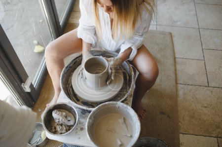 Téléchargez les photos : Une femme travaille au volant d'un potier. Création de vaisselle artisanale. - en image libre de droit