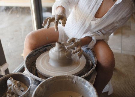 Photo for A woman works with clay in a workshop. Making pottery. - Royalty Free Image