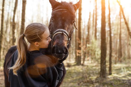 Foto de Una joven jinete abraza a un caballo. - Imagen libre de derechos