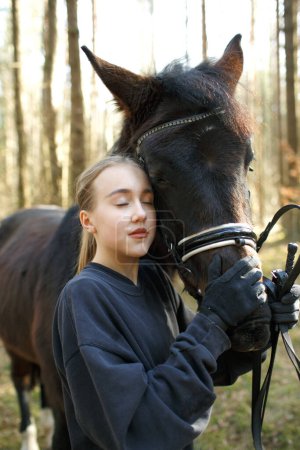 Foto de Una joven jinete abraza a un caballo. - Imagen libre de derechos