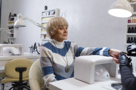 Téléchargez les photos : Une femme âgée fait une manucure professionnelle dans un salon de beauté. - en image libre de droit