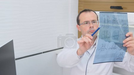 Foto de Un médico masculino examina los resultados de una tomografía computarizada del cerebro - Imagen libre de derechos